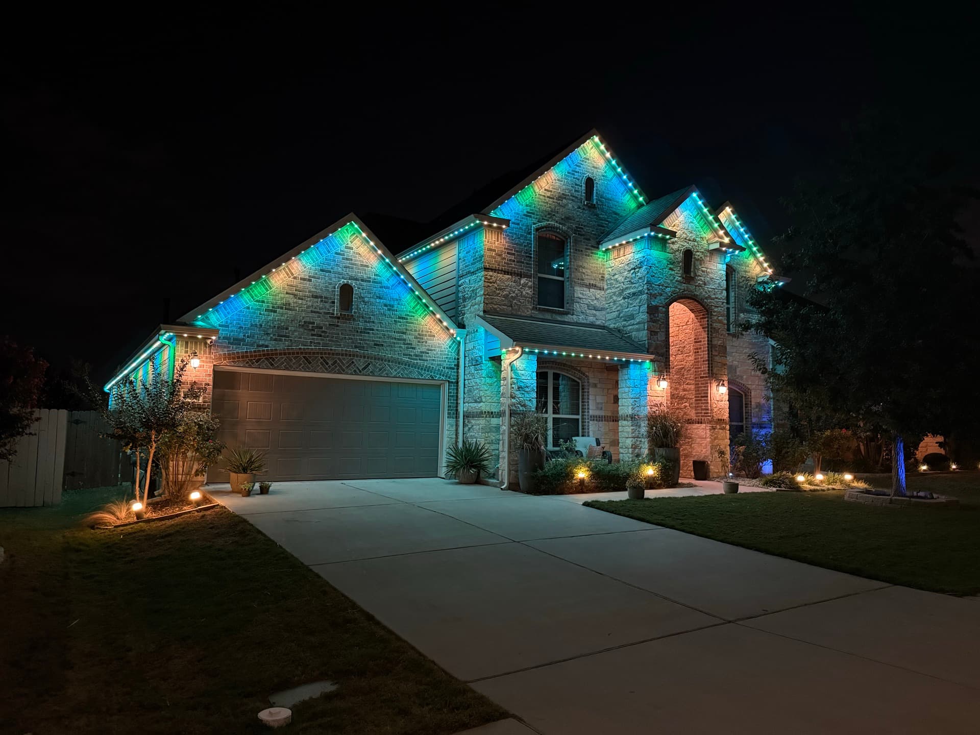 Soft warm white mood lighting on an Austin limestone home at dusk