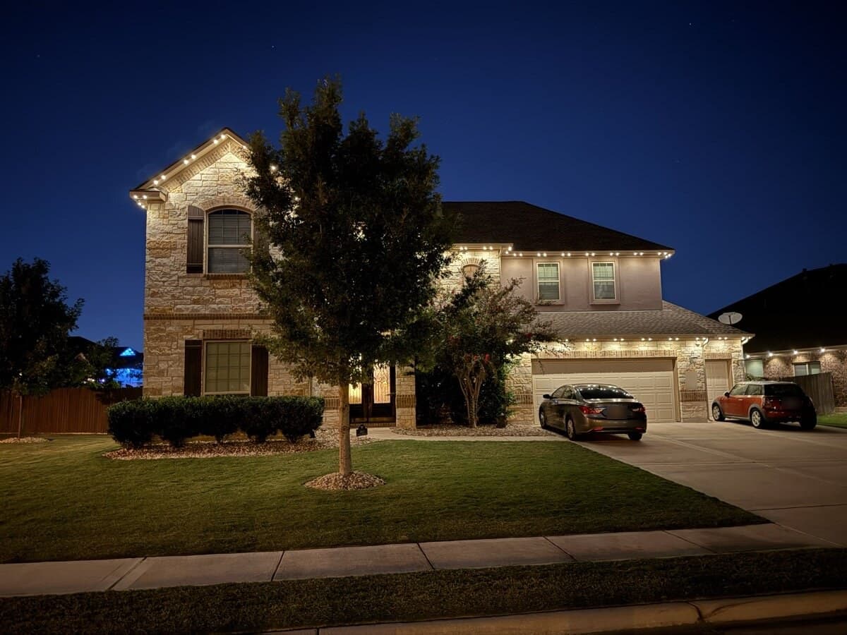 TruLight permanent roofline lighting in warm white on a Pflugerville home at night