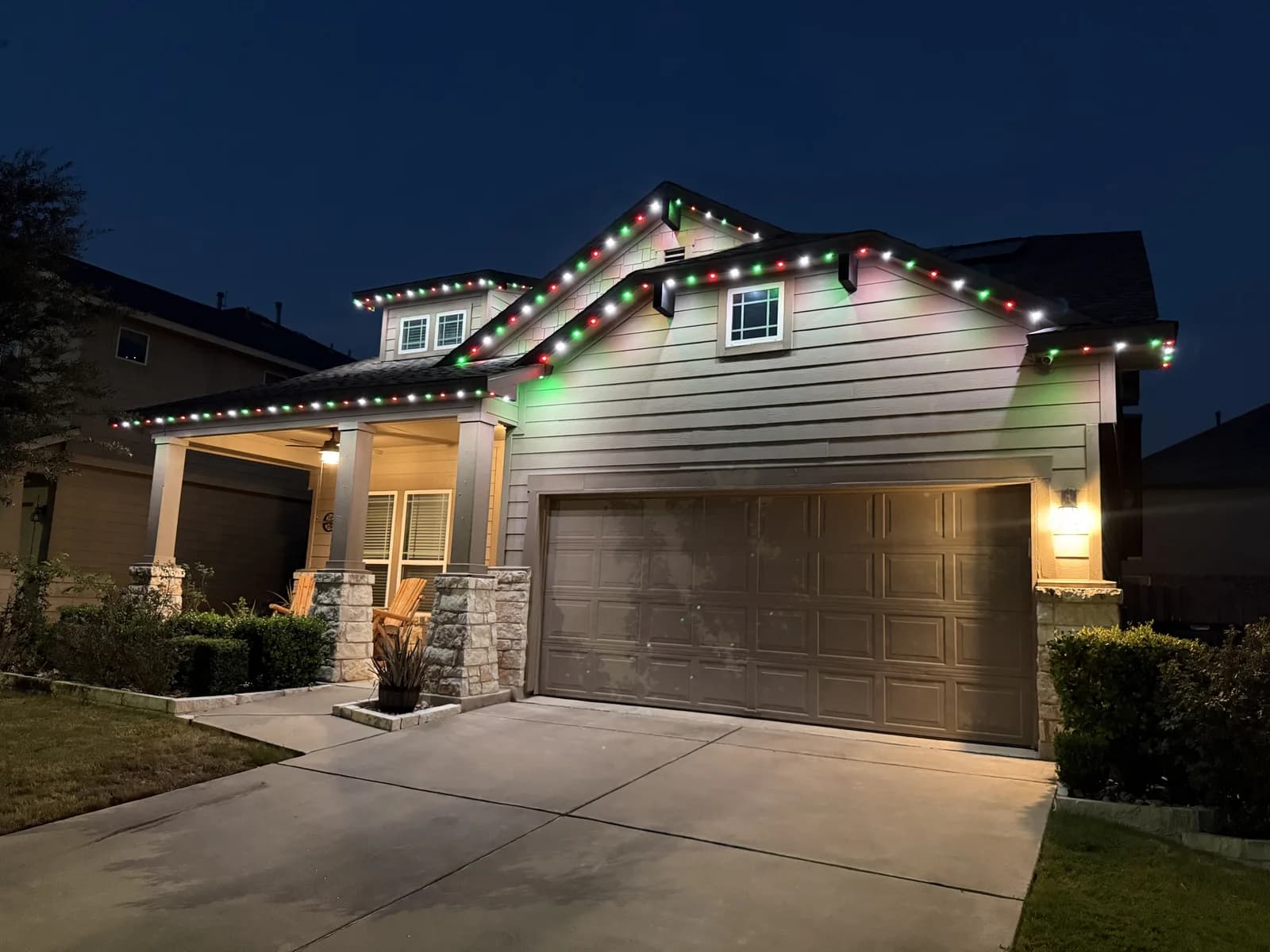Red, green, and white roofline lights on the same Pflugerville home.