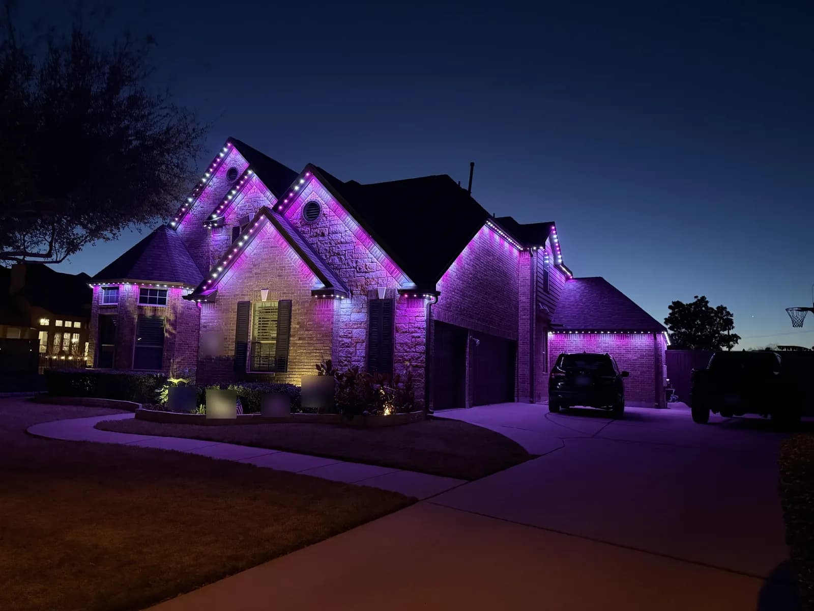 Pink and white lighting on a brick-and-stone home in Round Rock.