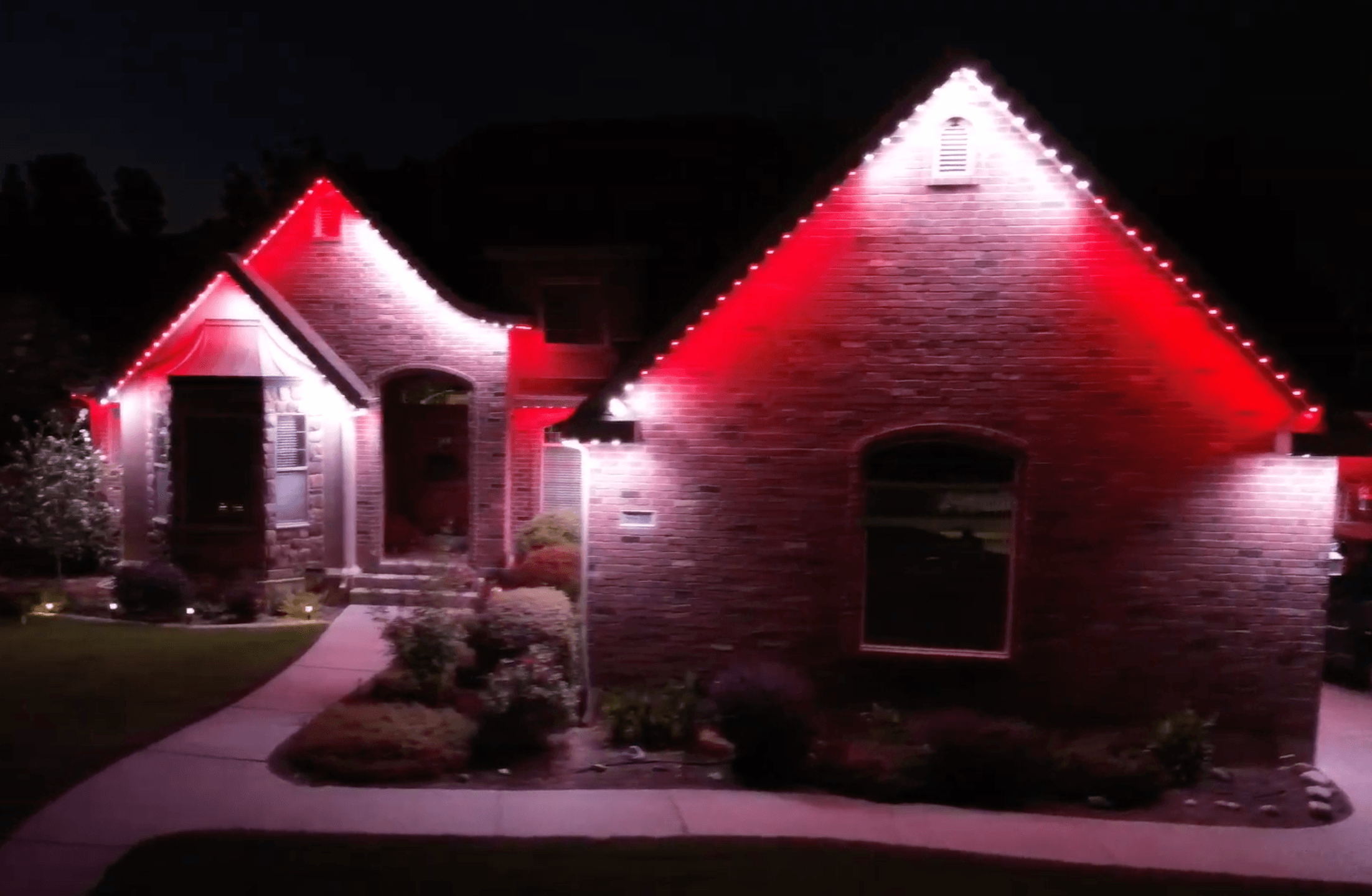 Permanent Christmas lights in candy cane red and white pattern on an Austin home