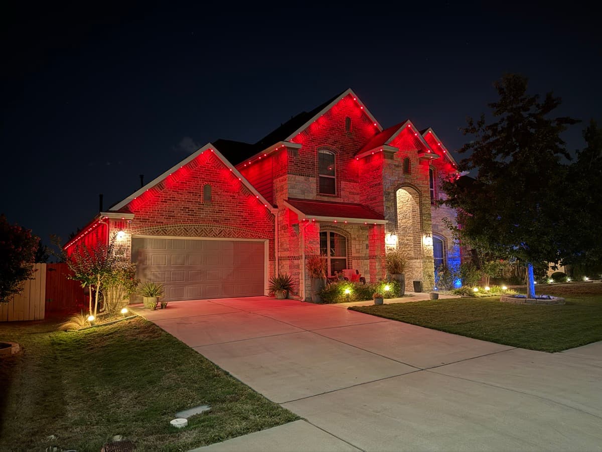 Austin Hill Country home with permanent LED motion sensor security lighting across the entire roofline at night