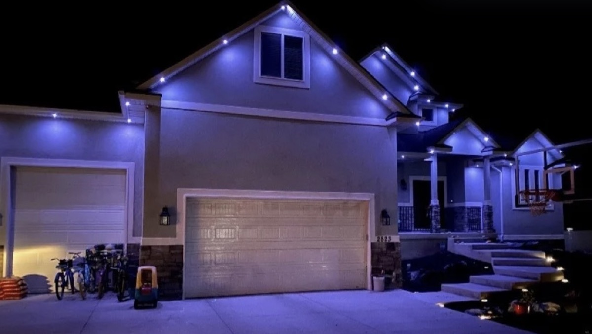 Austin home lit with deep blue color mode showing how dramatic permanent lighting color choices change a home's appearance at night