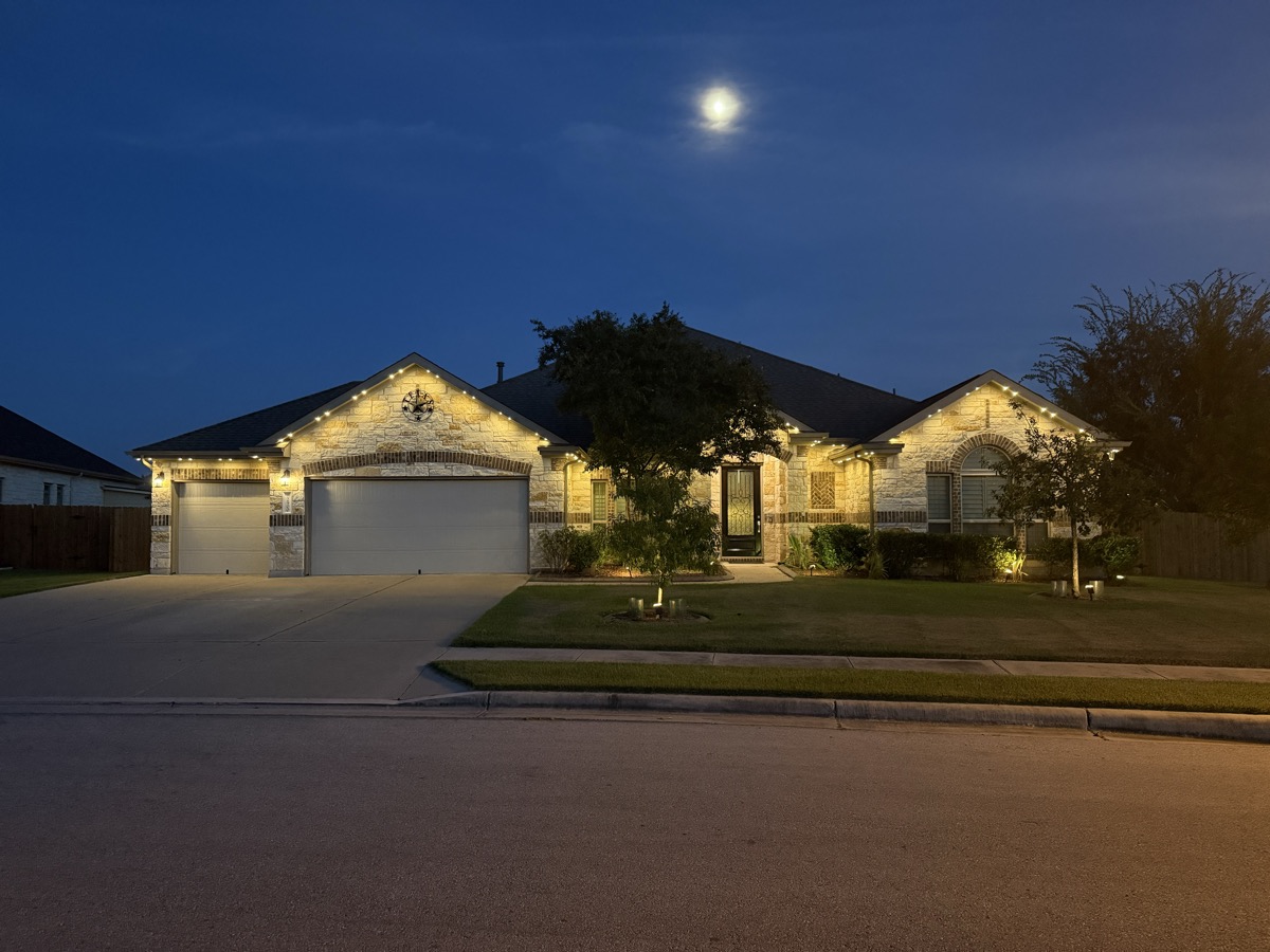 True warm white RGBW permanent lighting on a limestone Austin home at night